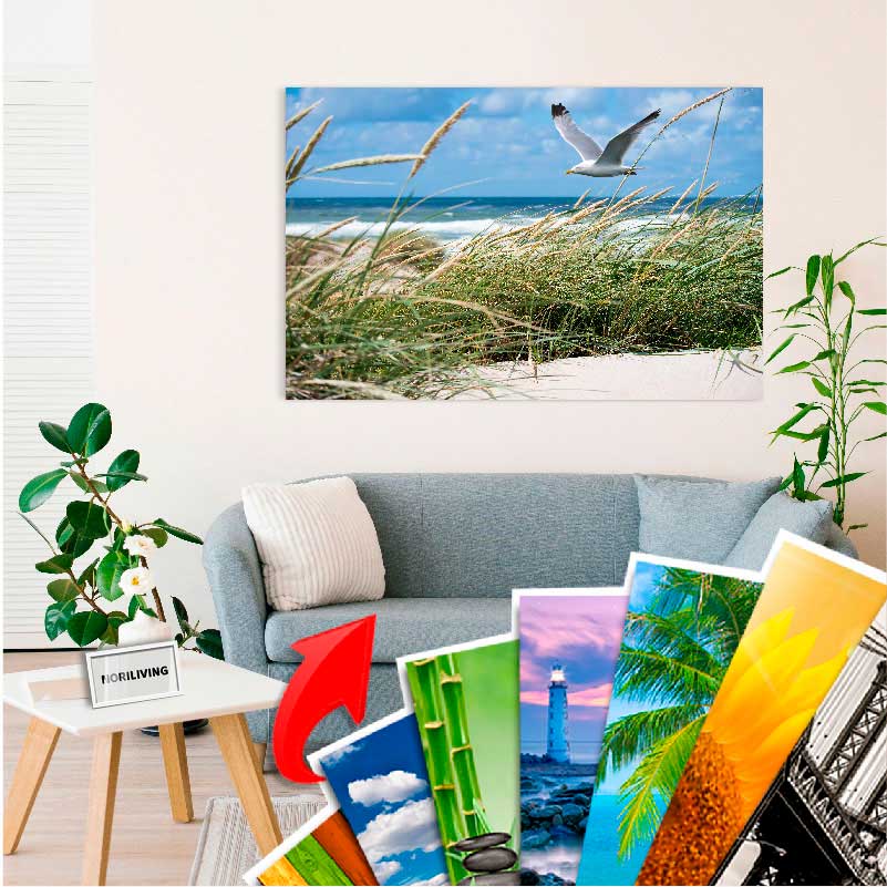 Wohnzimmer mit Sofa und Wandbild mit Strandmotiv, umgeben von mehreren Postervarianten
